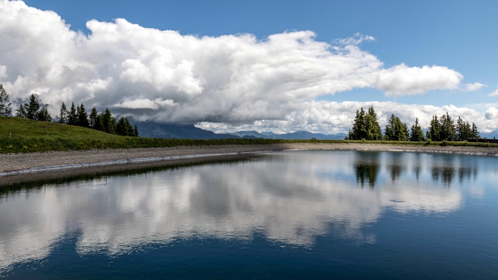 a large body of water surrounded by a lush green hillside