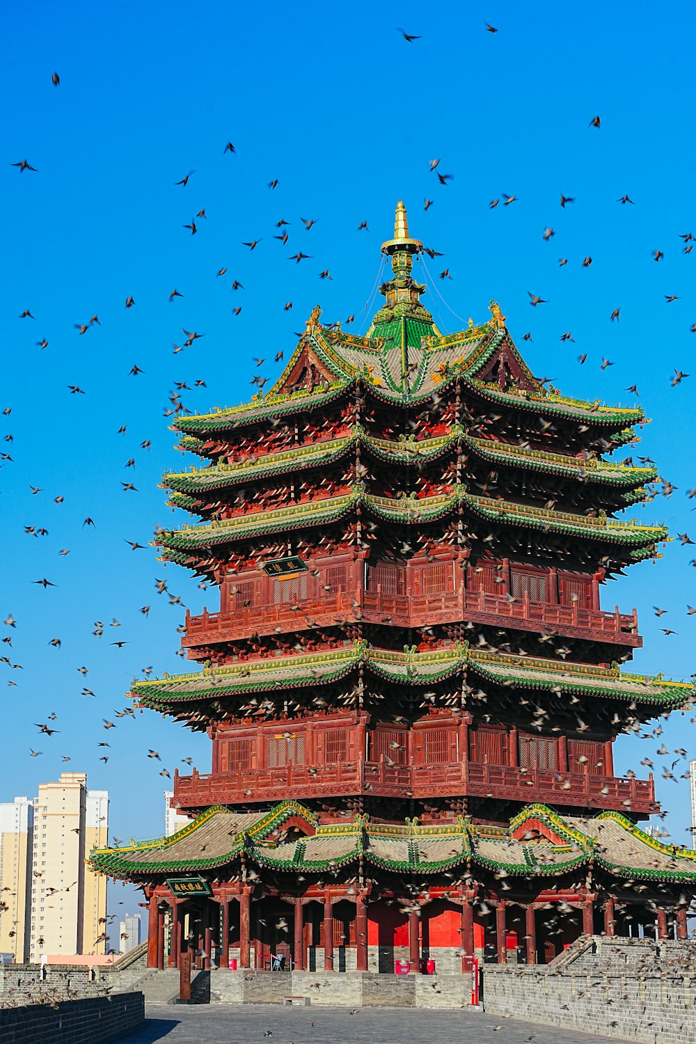 una grande torre con uccelli che volano intorno ad essa