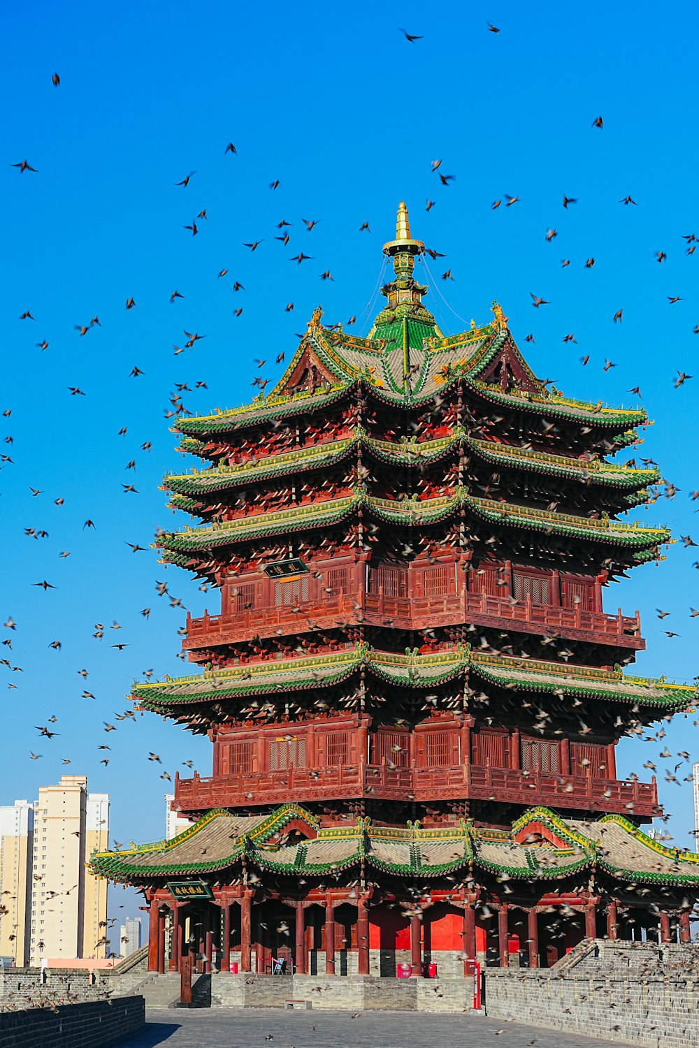 a large tower with birds flying around it