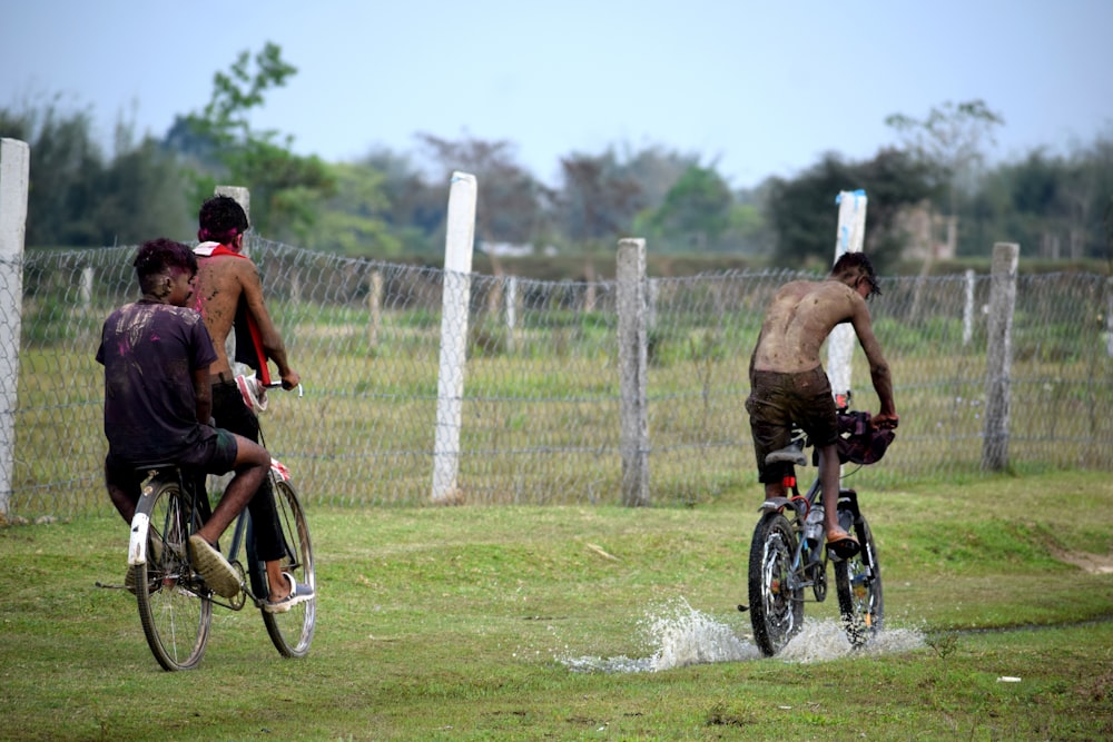 a group of people riding bikes through a field