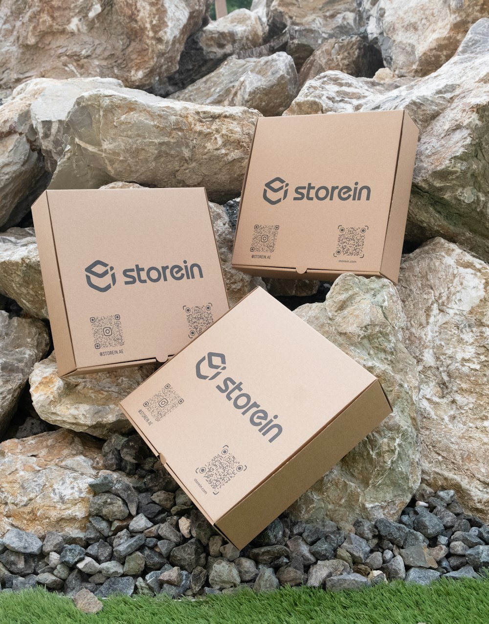three boxes sitting on top of a pile of rocks