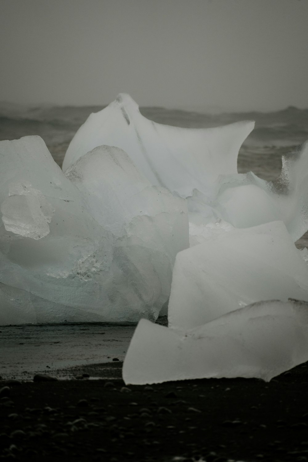 a pile of ice sitting on top of a beach