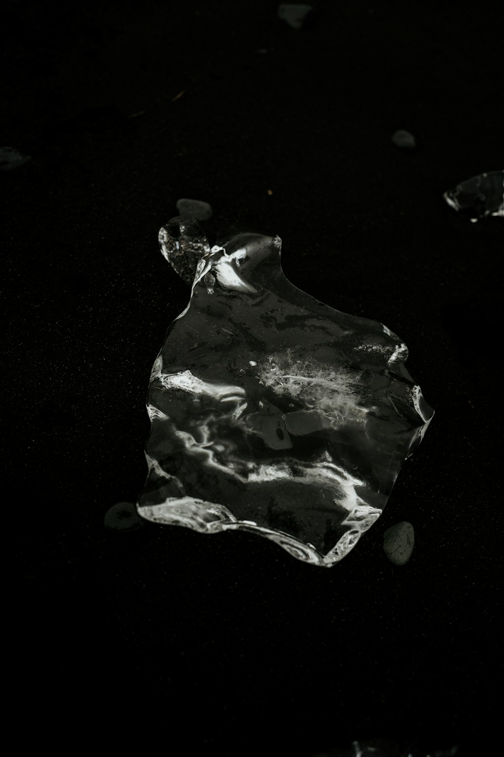a piece of ice sitting on top of a black surface