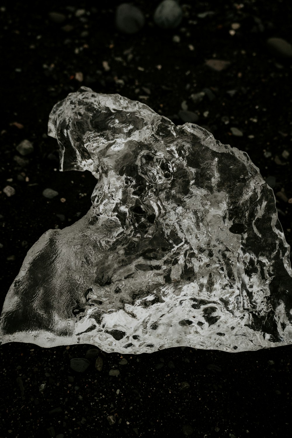 a piece of ice sitting on top of a black ground