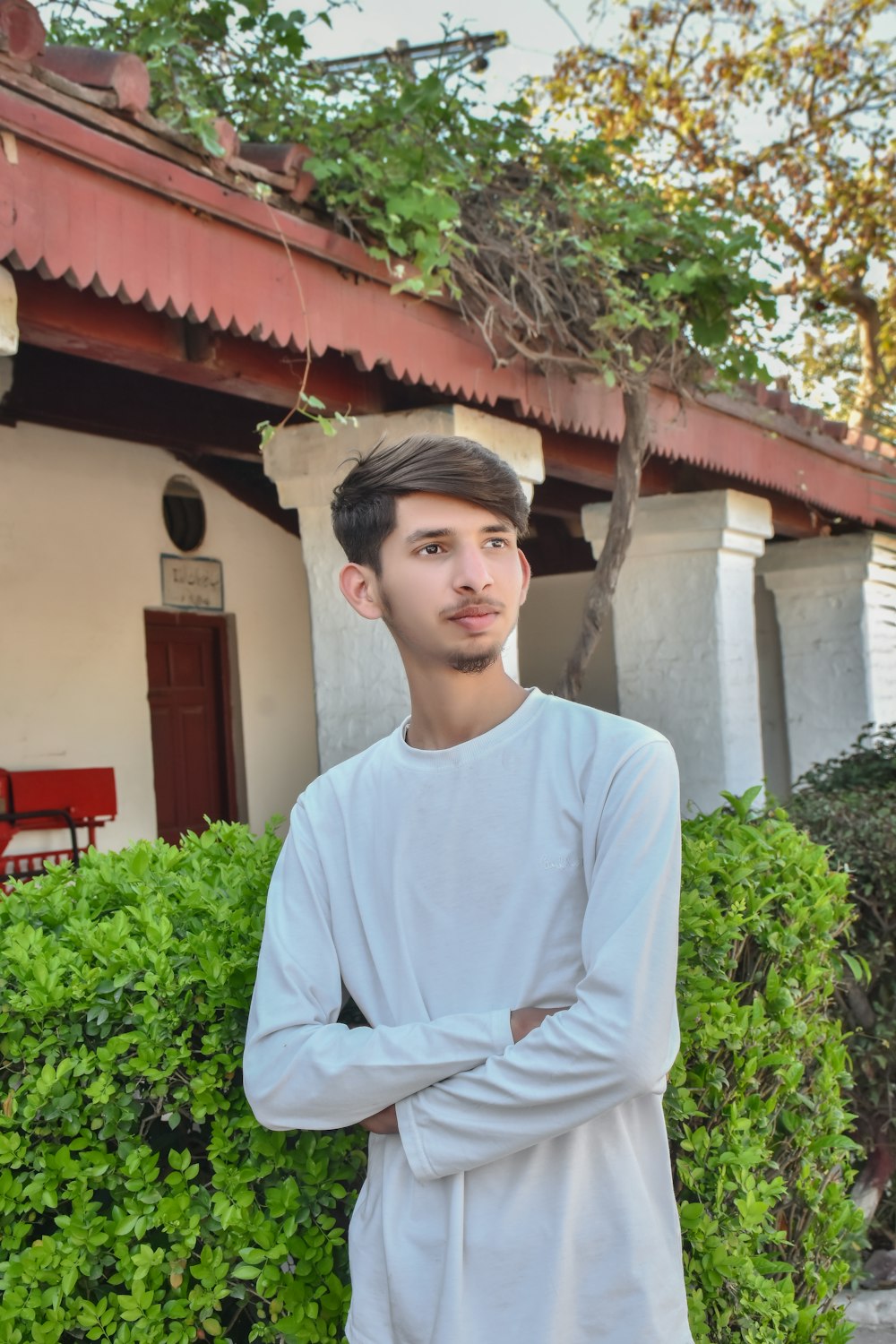 a young man standing in front of a house