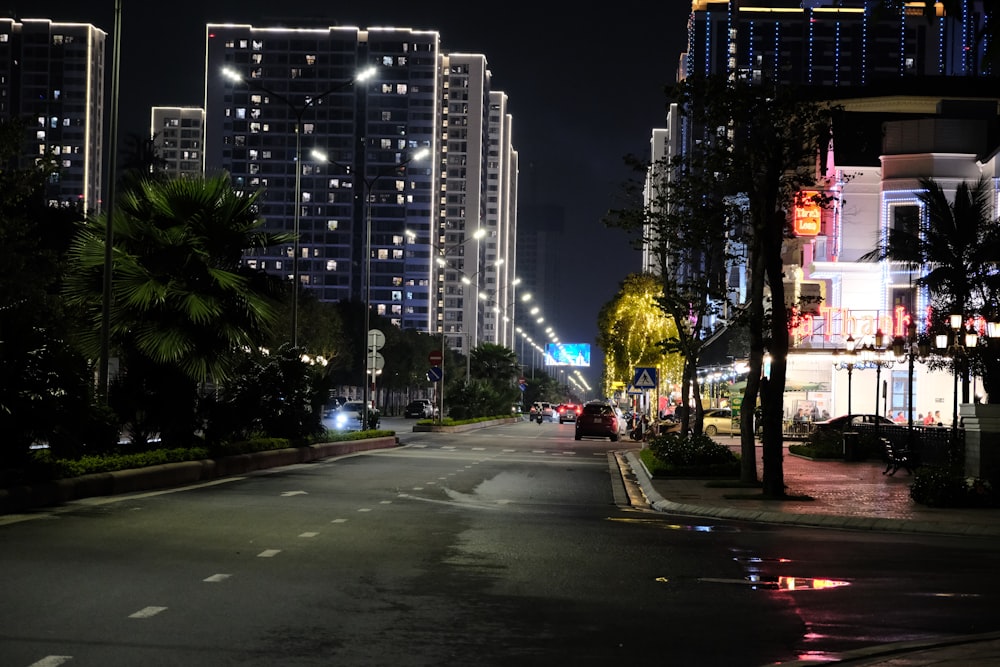 a city street at night with tall buildings