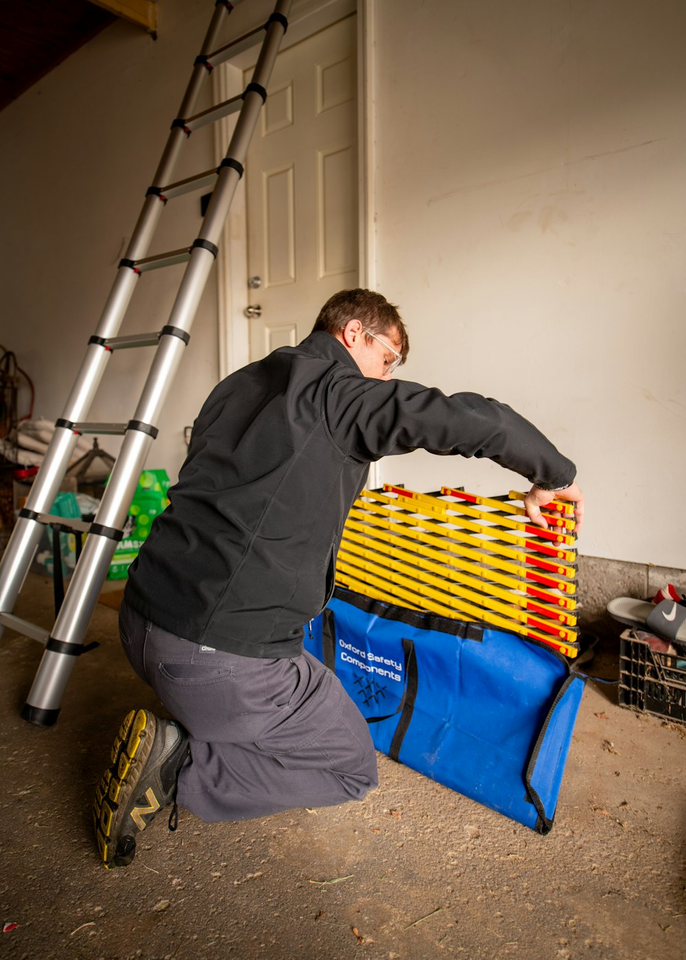 a man kneeling down next to a ladder