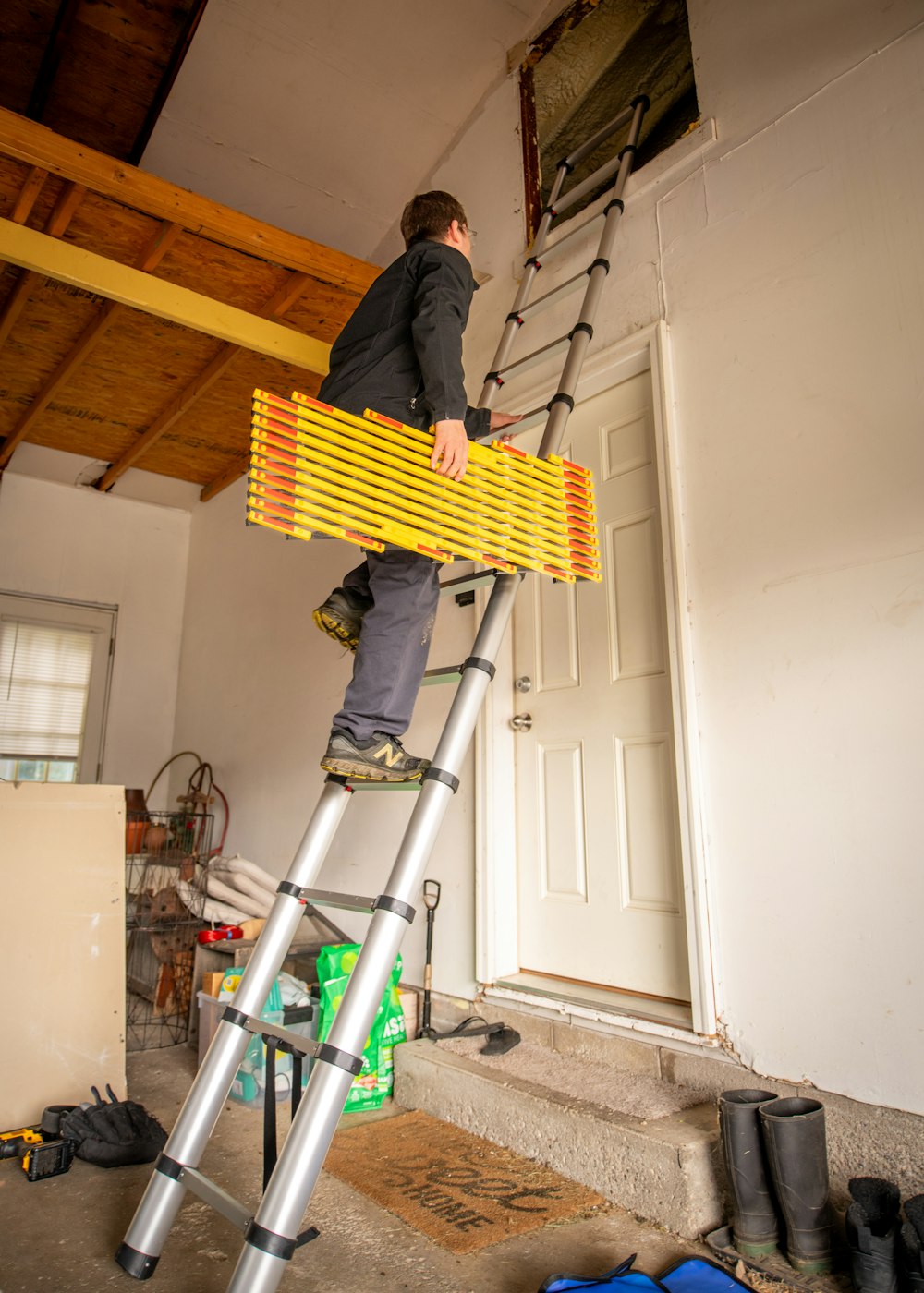 a man standing on a ladder working on a door