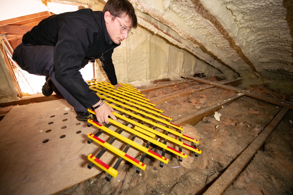 a man working on a floor in an attic