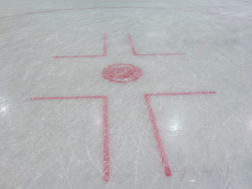a cross drawn on the ice on a hockey rink