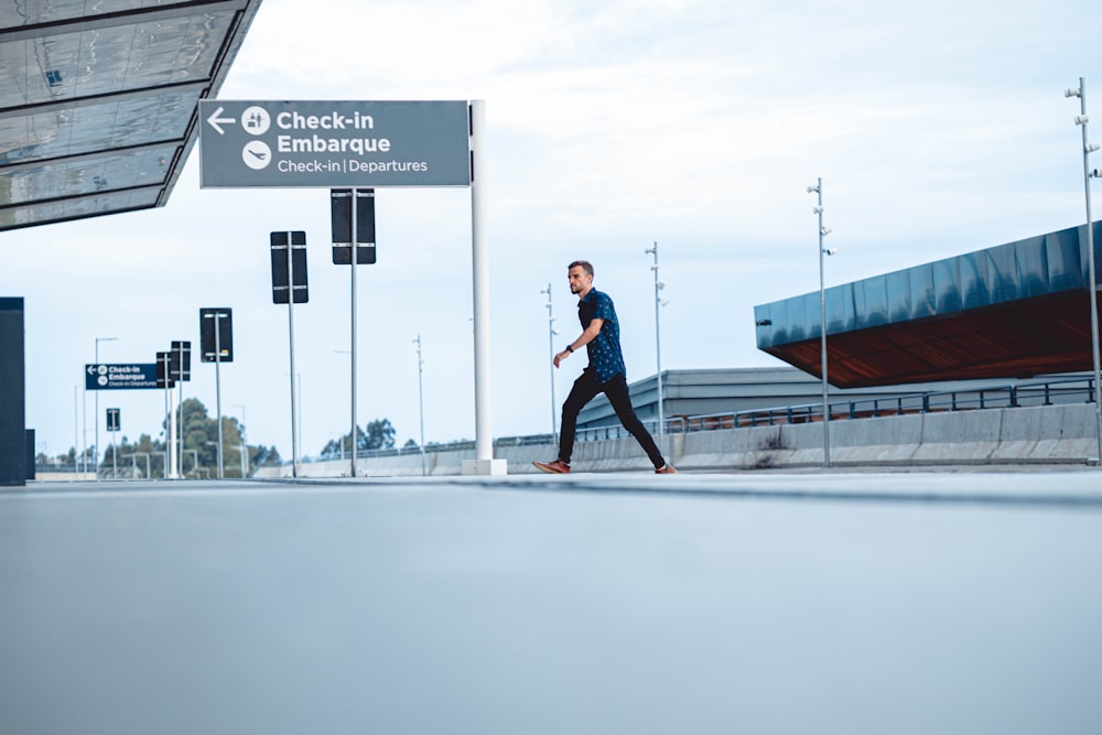 a man walking across a street next to a traffic light