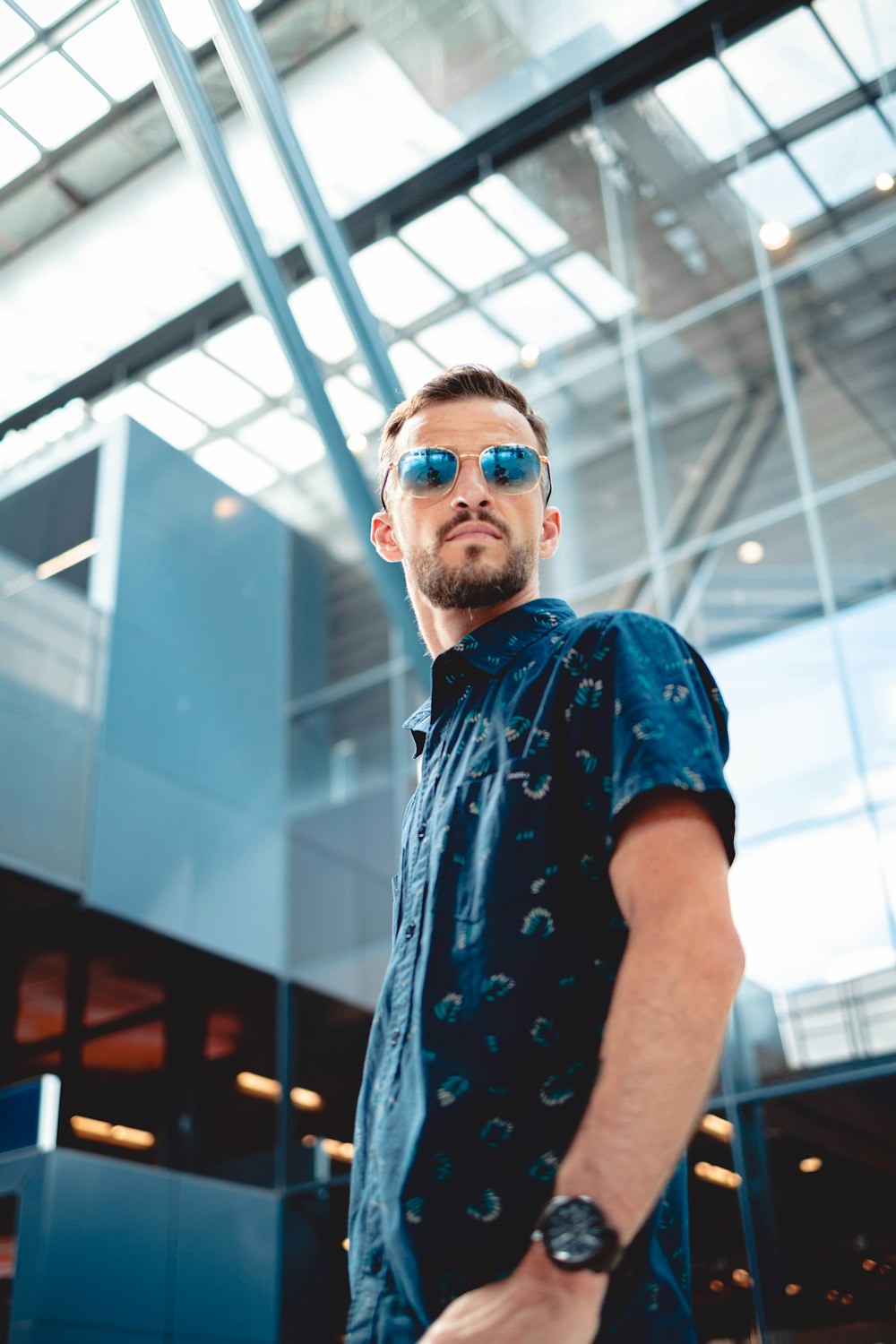 a man wearing sunglasses standing in front of a building