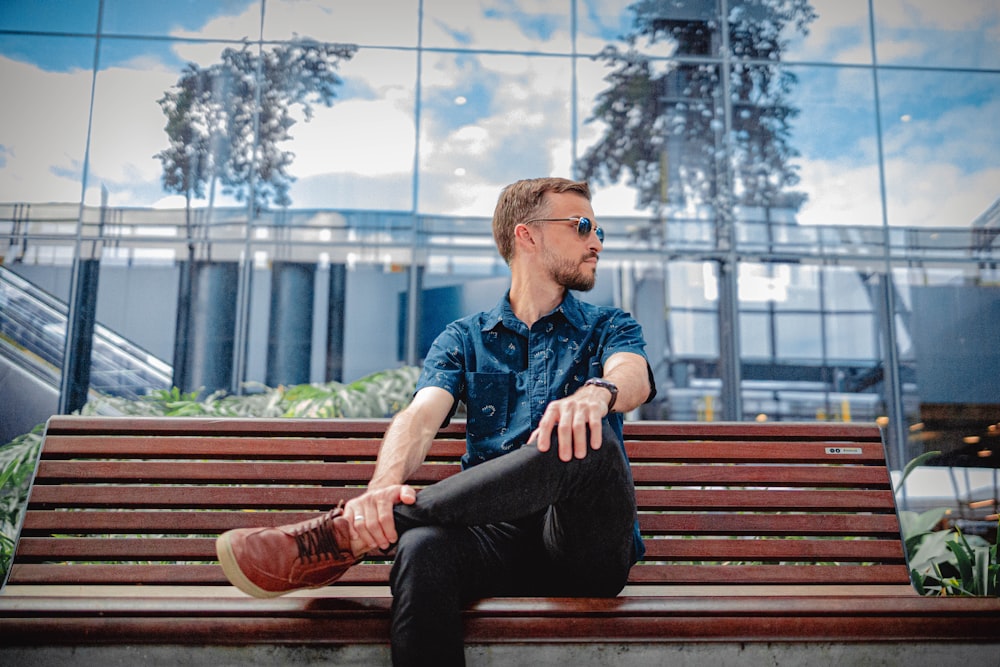 a man sitting on a bench in front of a building