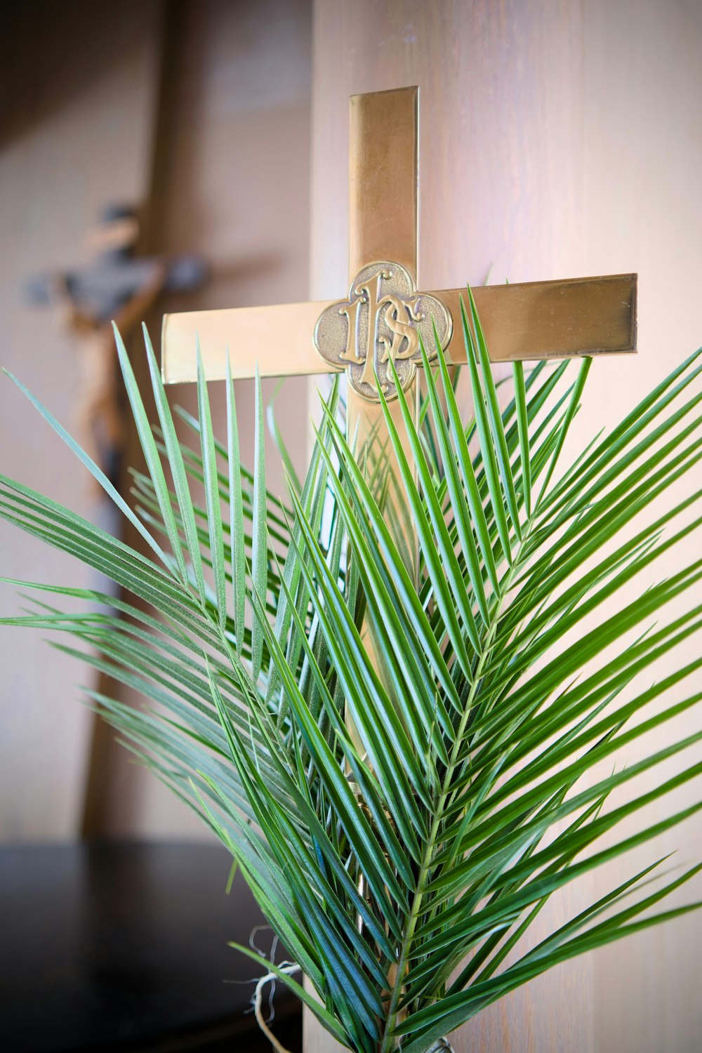 eine Palme in einer Vase mit einem Kreuz darauf