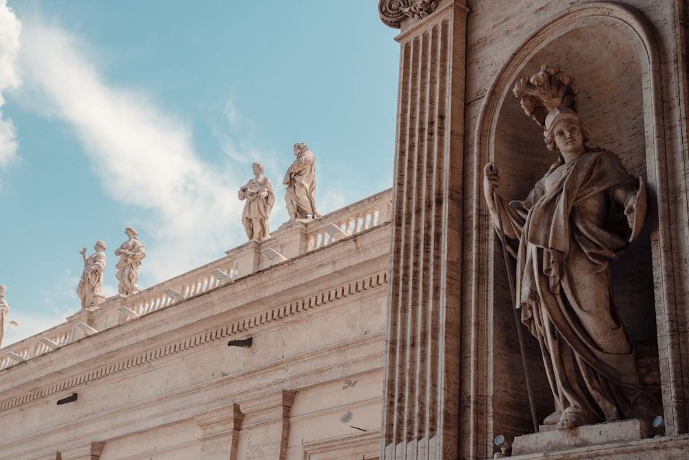 a tall building with statues on top of it