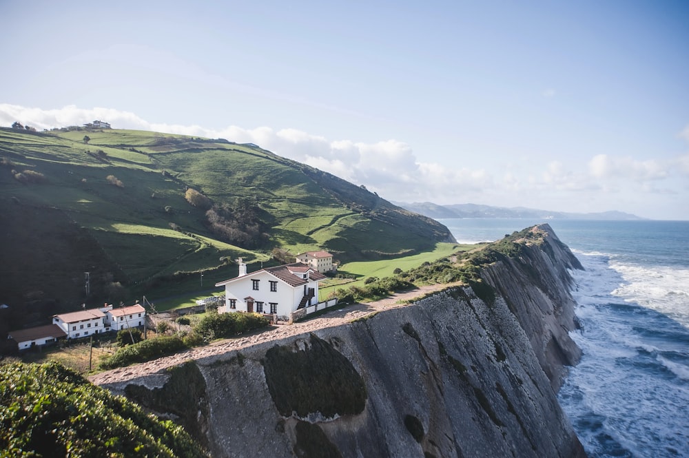 a house sitting on top of a cliff next to the ocean