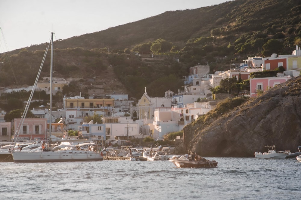 a harbor filled with lots of boats next to a hillside