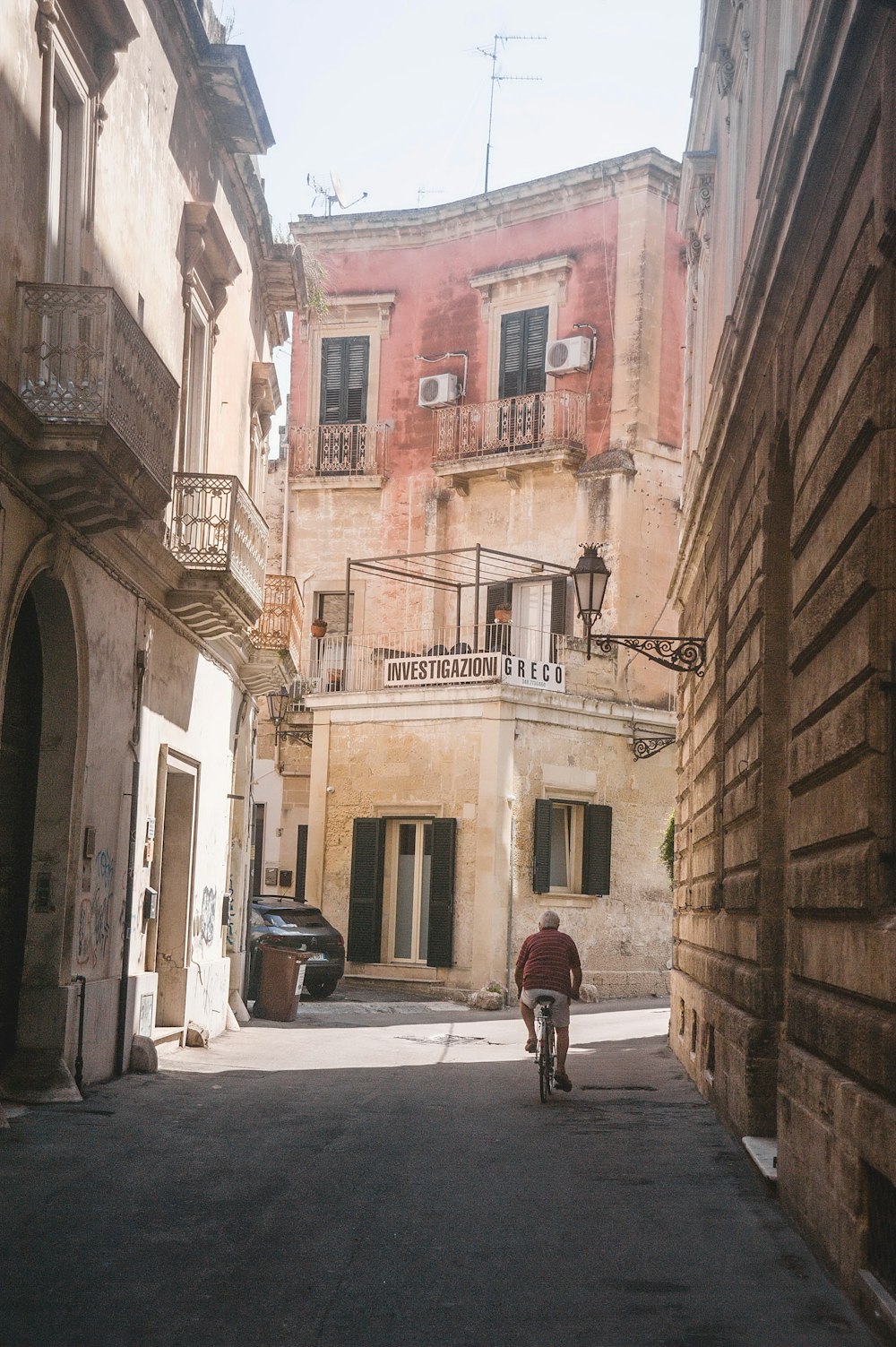 a man riding a bike down a street next to tall buildings