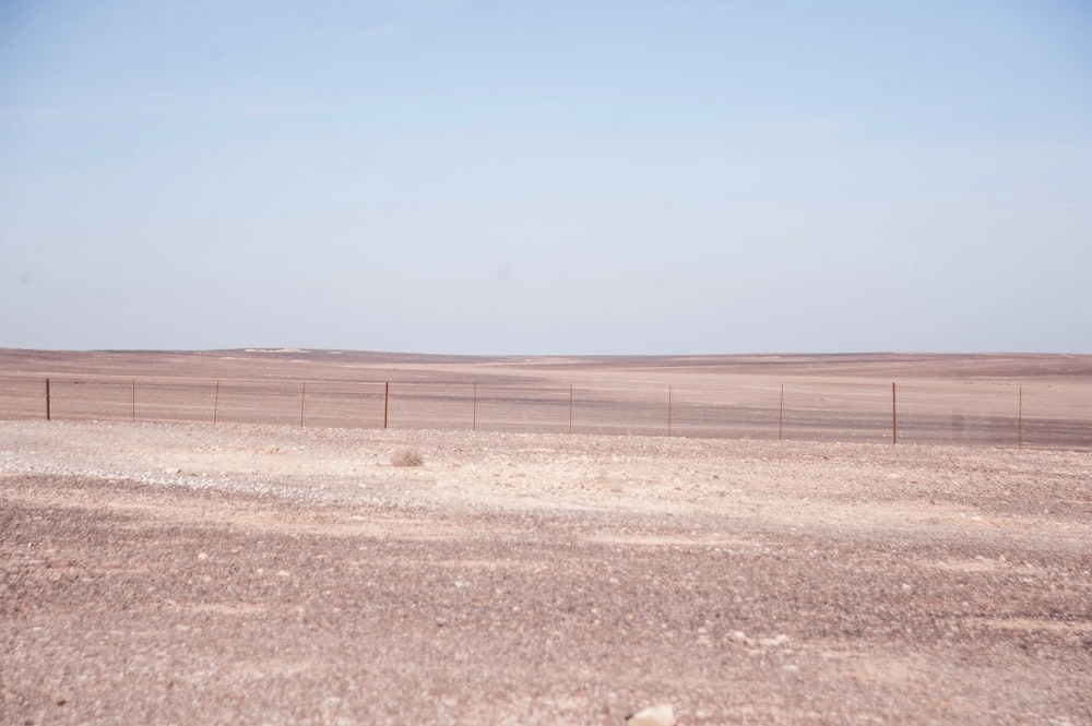 an empty field with a fence in the middle of it