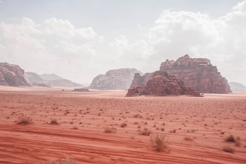 a desert scene with a rock formation in the distance