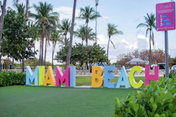 a sign that says miami beach in multicolored letters