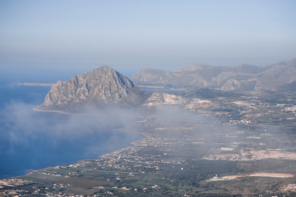 an aerial view of a mountain and a body of water