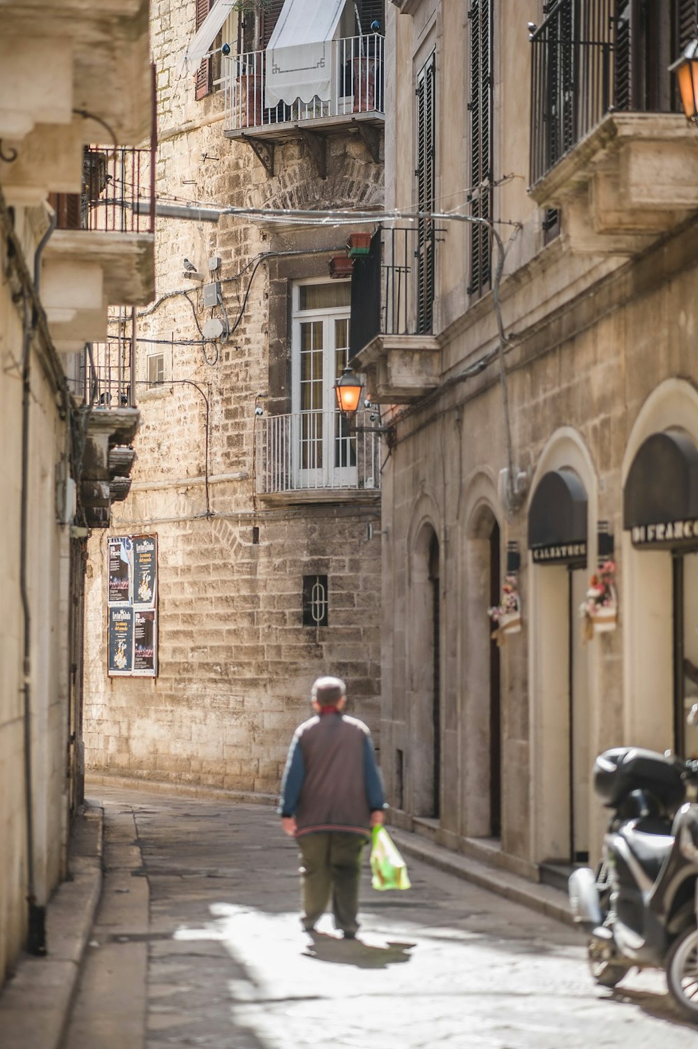 a man walking down a street next to tall buildings