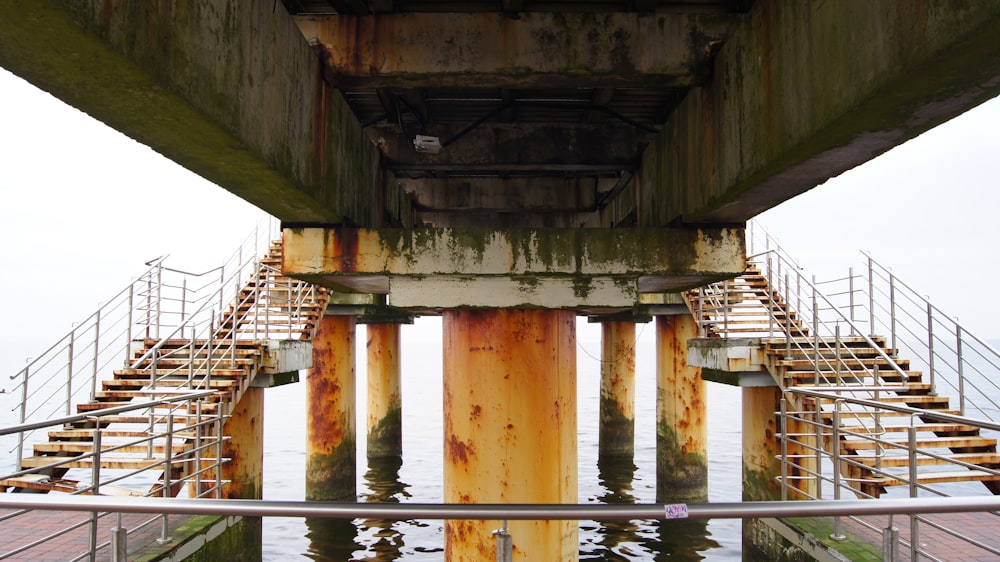 a view of the underside of a bridge over a body of water
