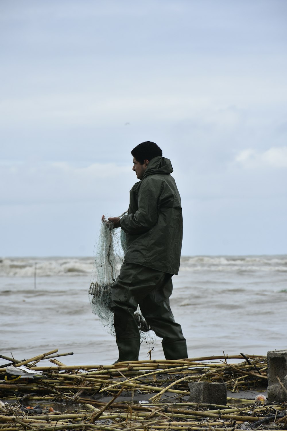 a man standing on a beach holding a fishing net