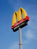 a mcdonald's drive thru sign against a blue sky