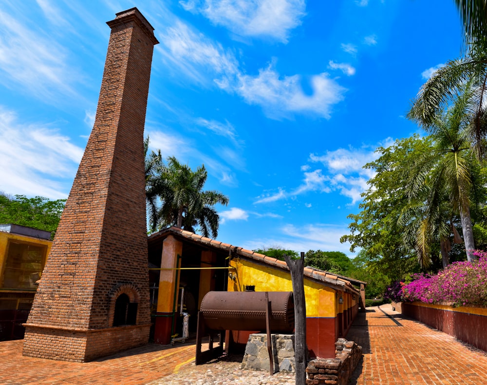 a brick building with a chimney and a bench in front of it