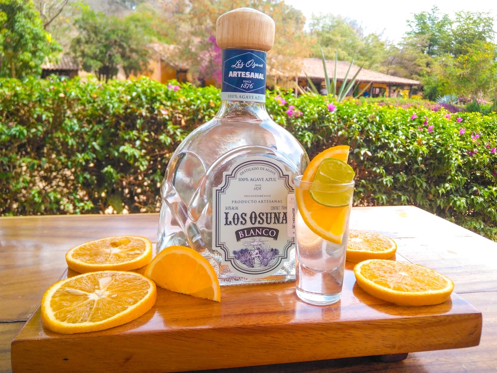 a bottle of kabob's gin sits on a cutting board with sliced