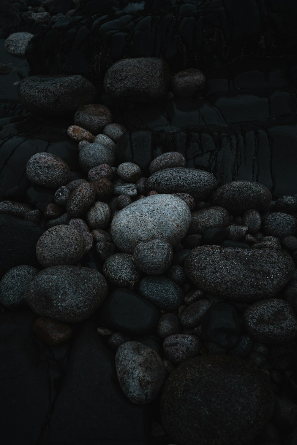 un mucchio di rocce seduto in cima a una spiaggia