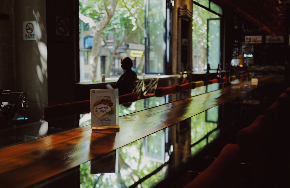 a person sitting at a bar in front of a window