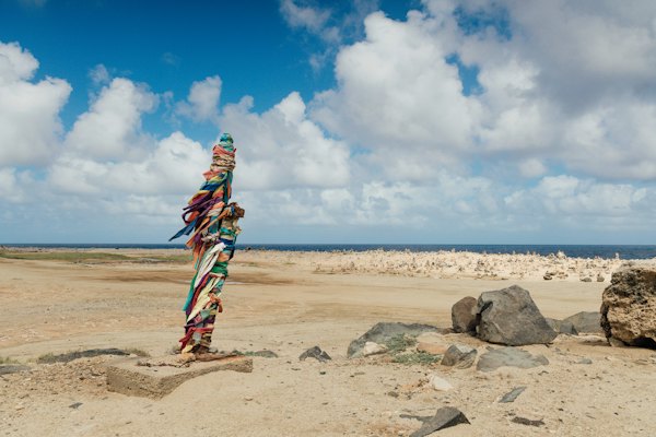 A woman standing on top of a sandy beach — Aruba, Aruba