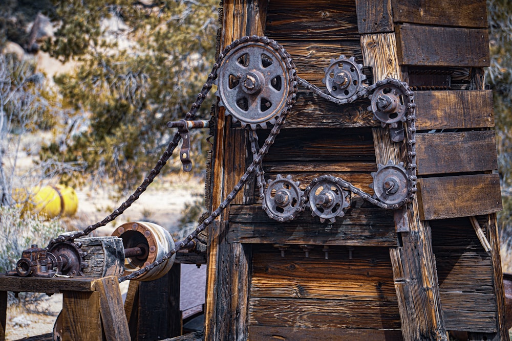 a wooden structure with metal wheels and chains
