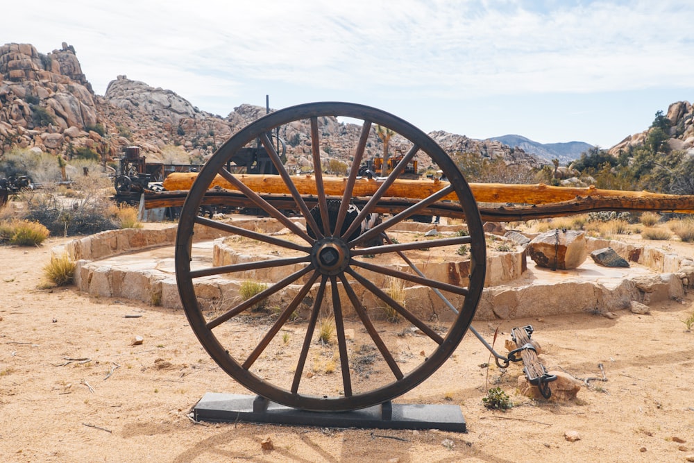 an old wagon wheel in the middle of a desert