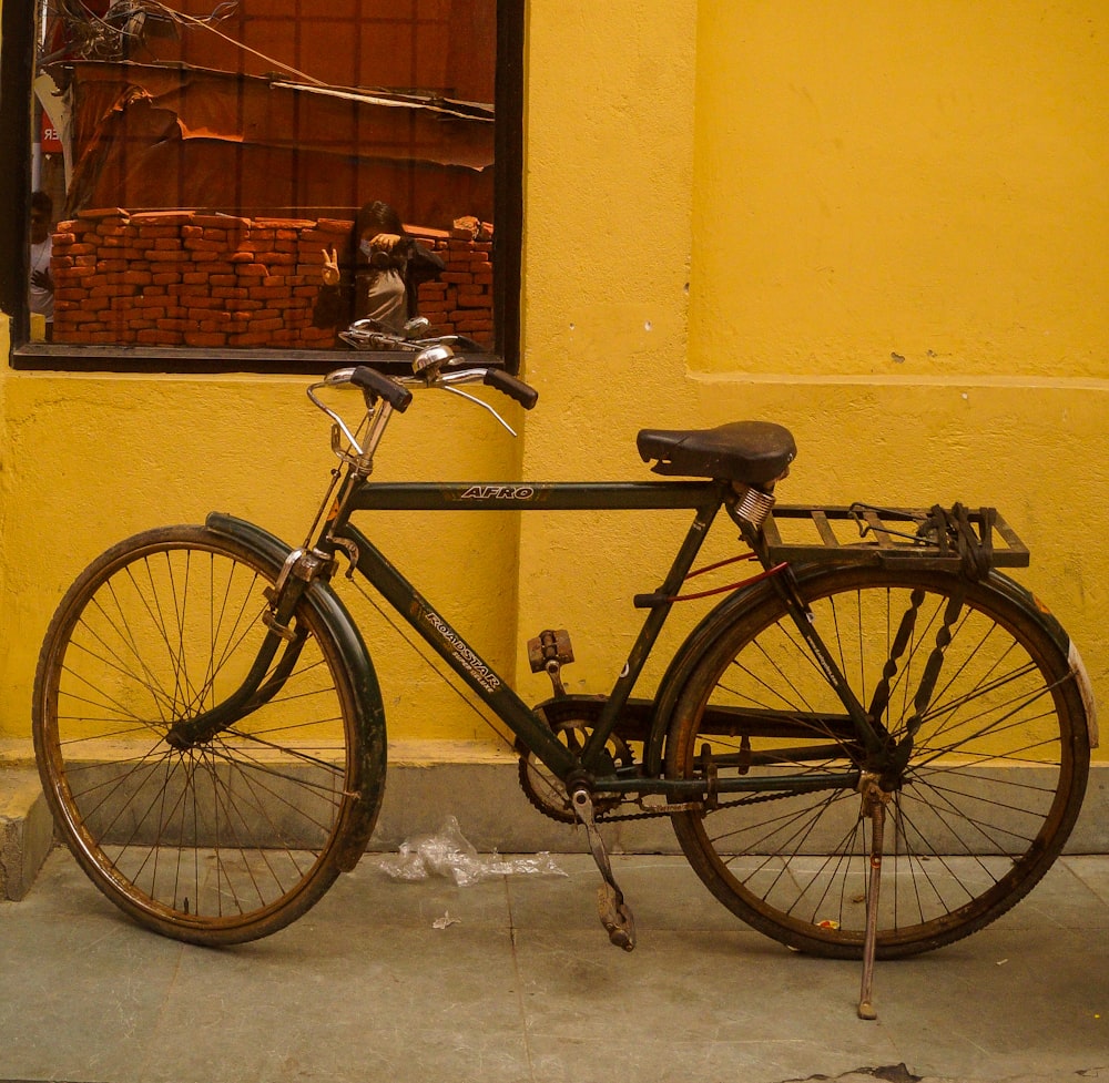 a bicycle parked in front of a yellow building