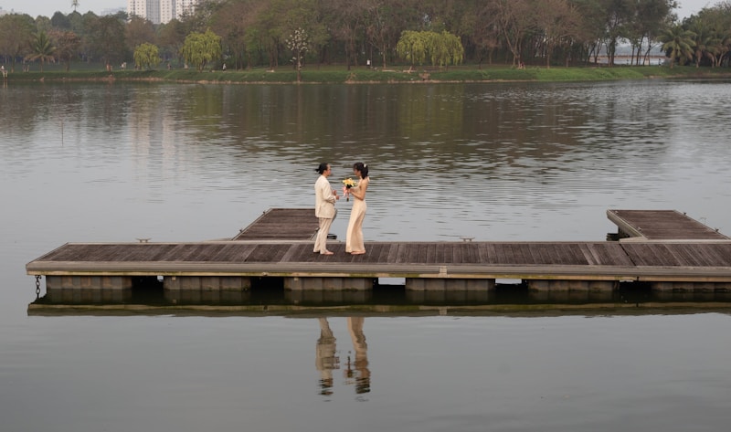 a couple of people standing on top of a pier