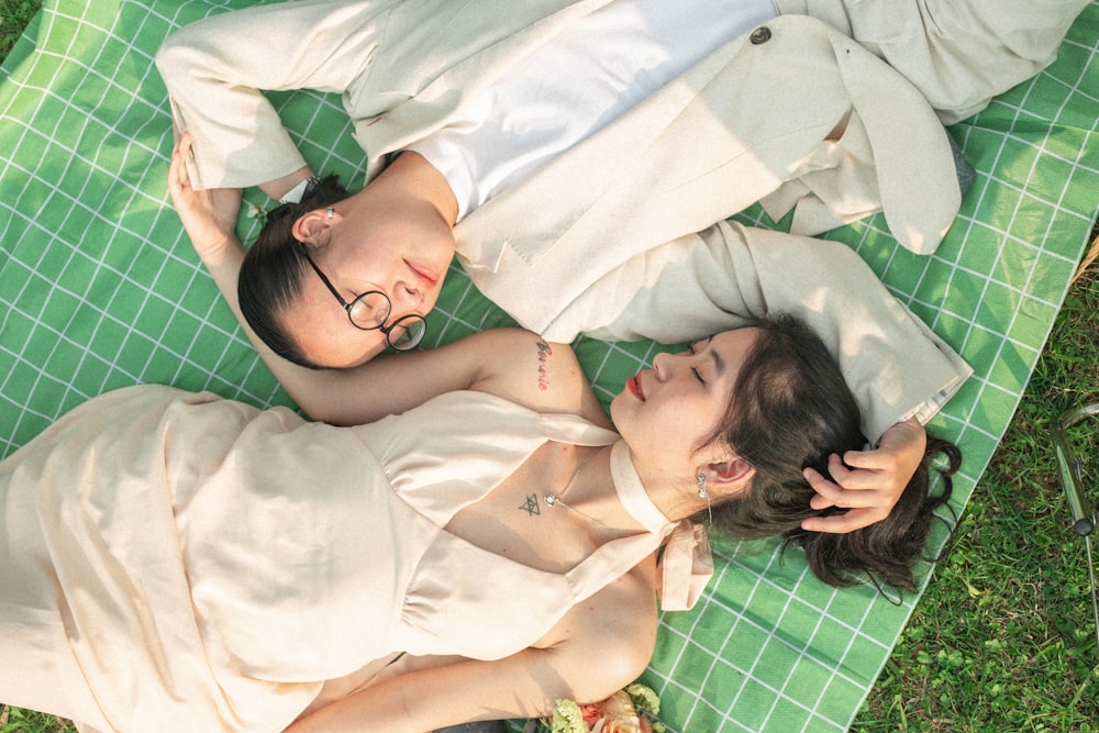 a man and a woman laying on a blanket