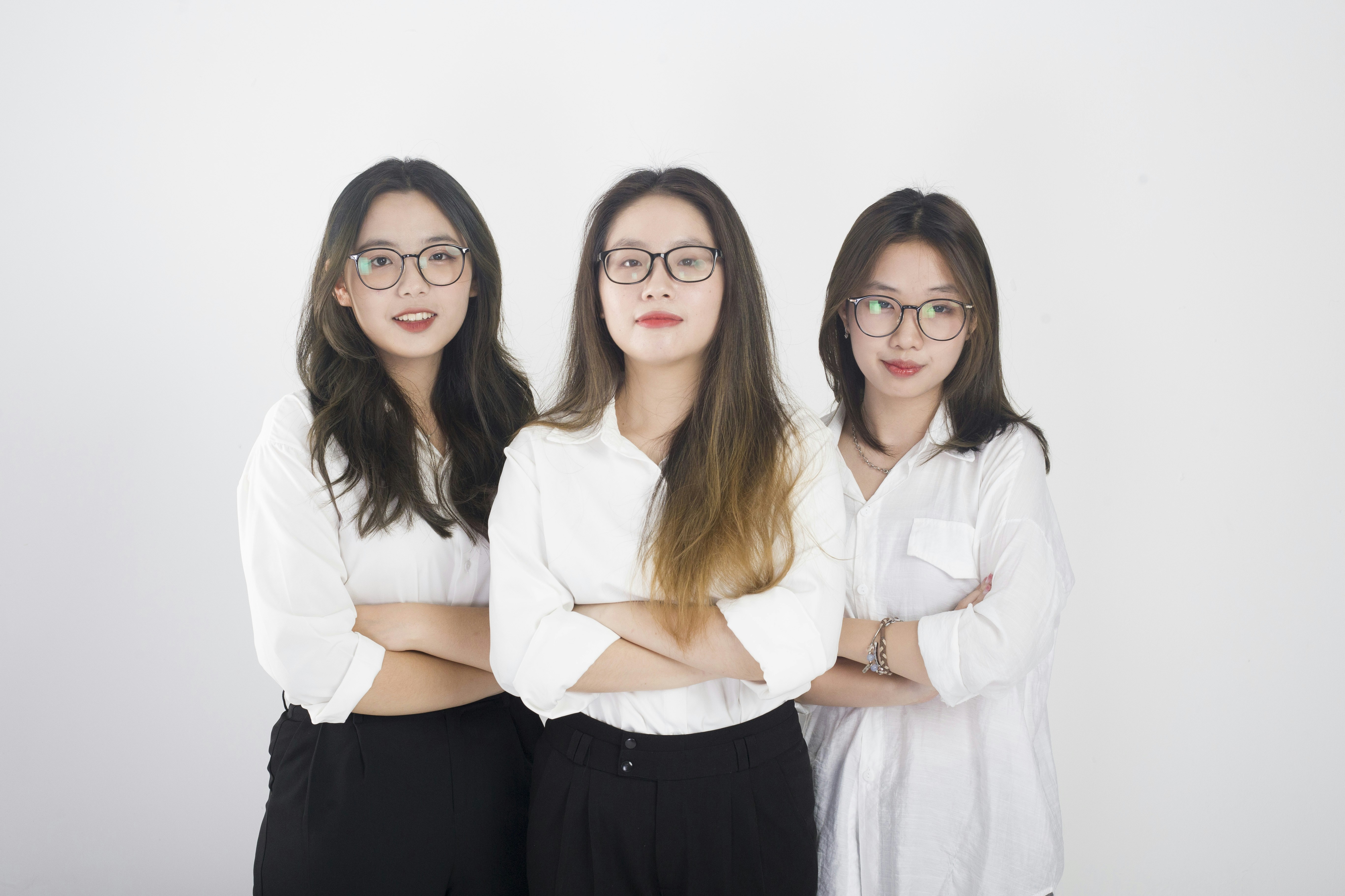 three women standing next to each other with their arms crossed