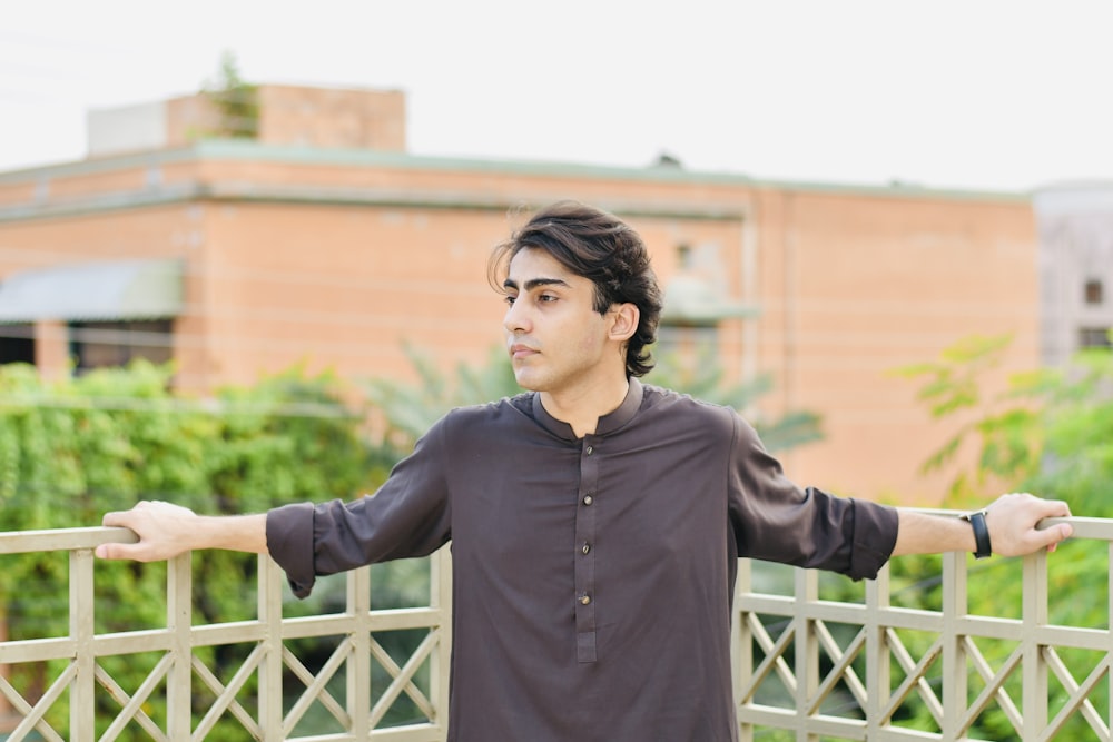 a man standing on a bridge with his arms outstretched