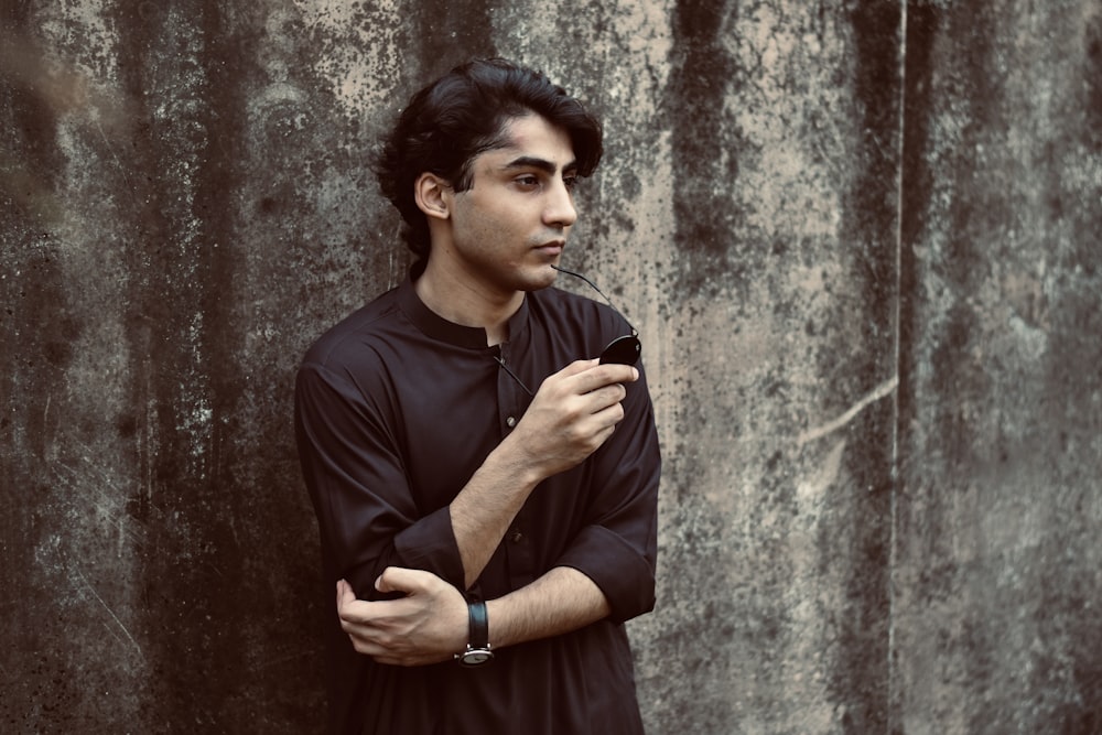 a man standing in front of a concrete wall