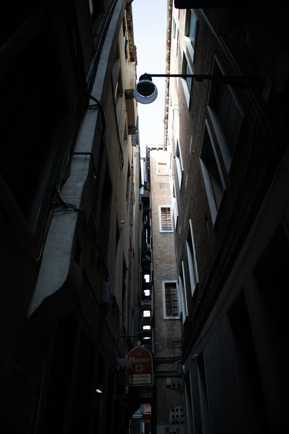 a narrow alleyway in a city with a street light