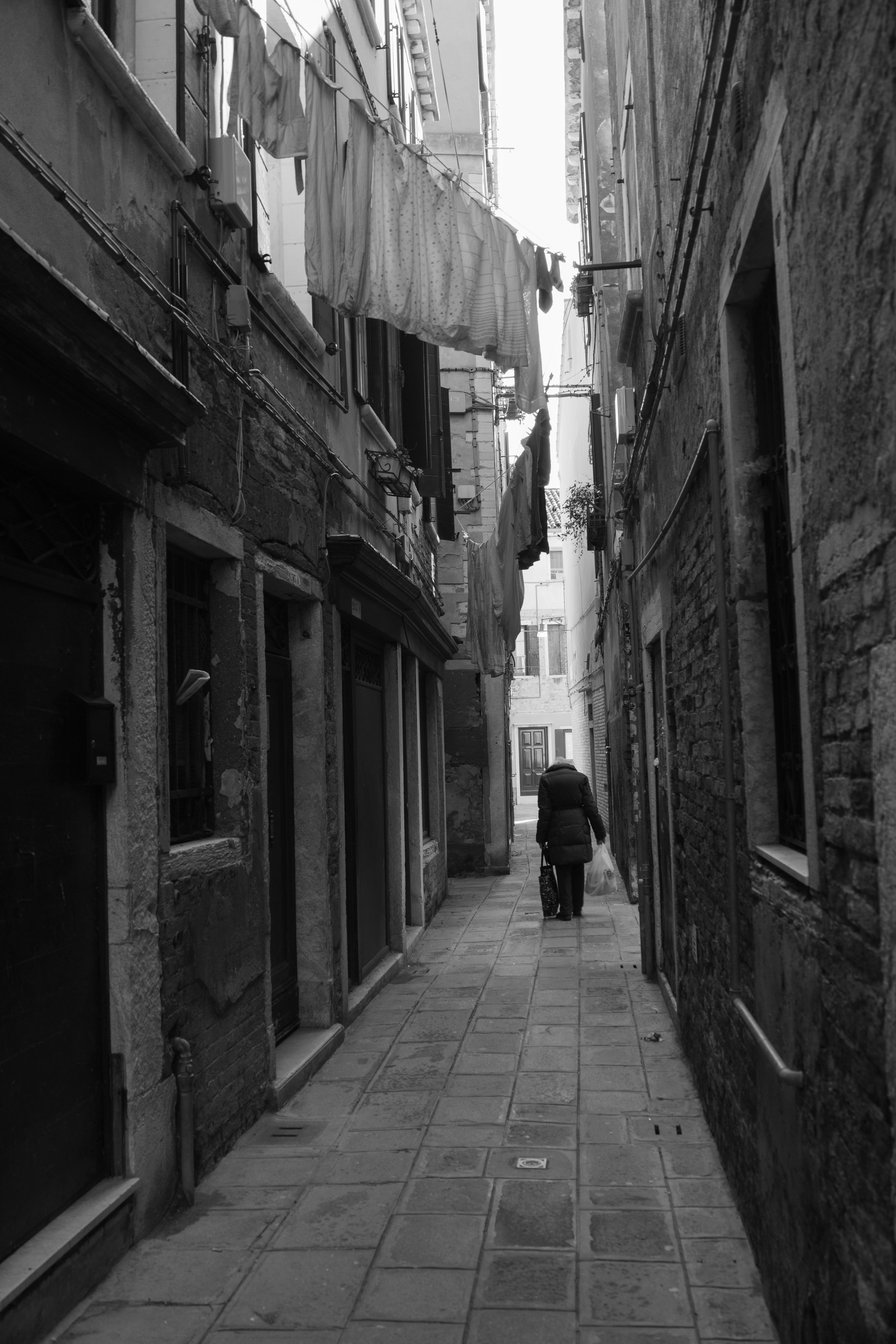 a person walking down a narrow alley way