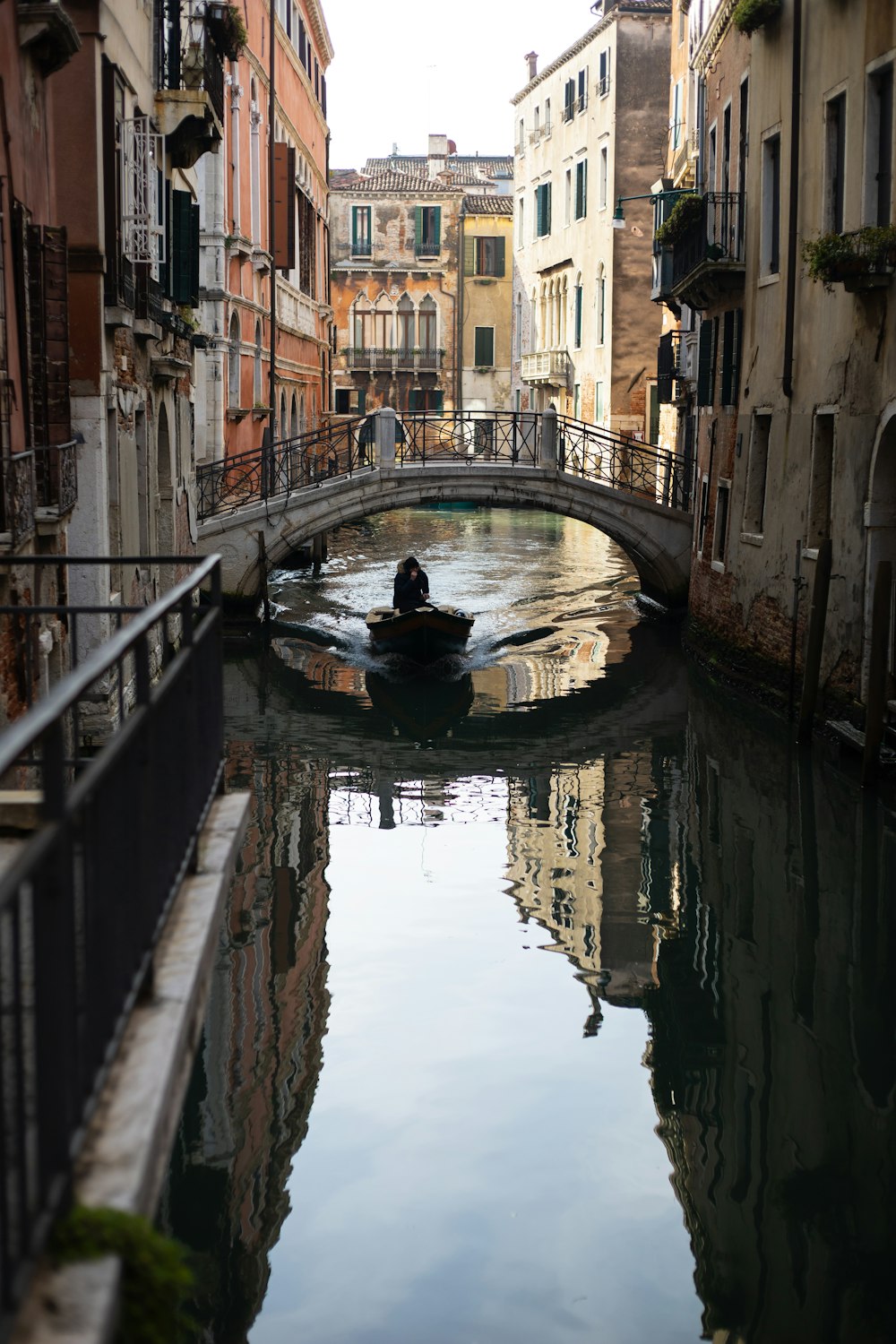 a small boat traveling down a canal next to tall buildings