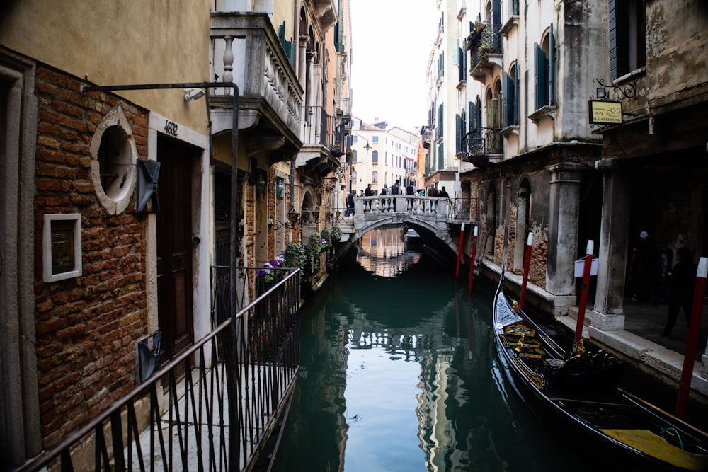 a narrow canal with a bridge in the background