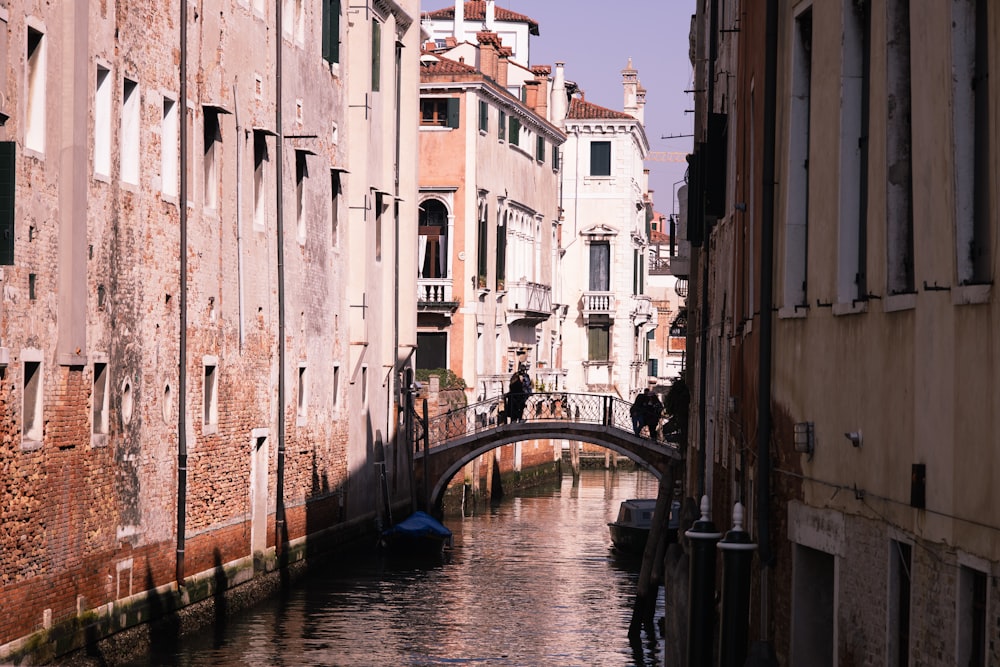 a narrow canal with a bridge in the middle of it