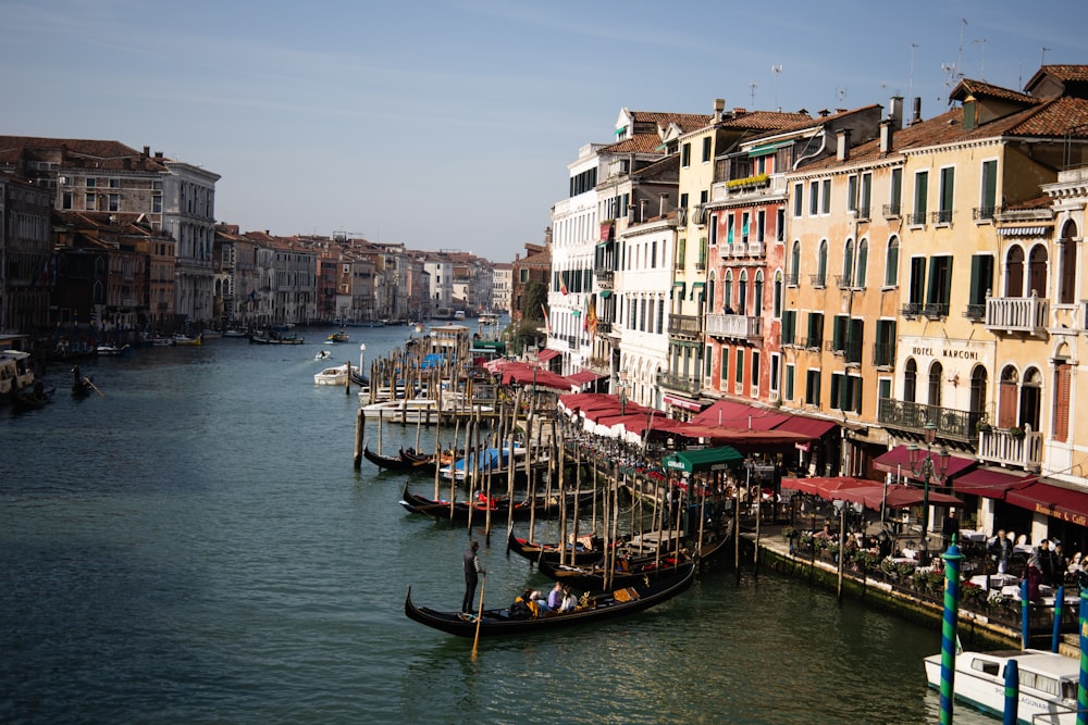 a boat is docked in the water next to a row of buildings