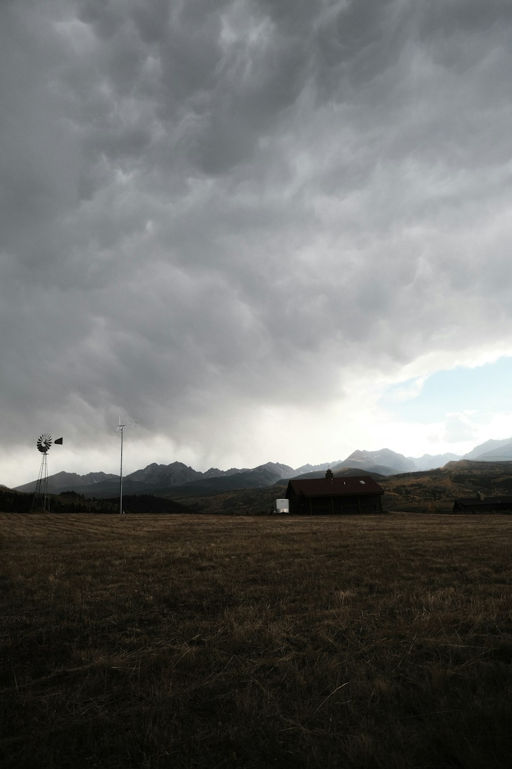 a field with a barn and a street light in the distance